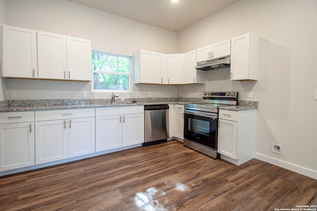 kitchen with dark wood-type flooring, light stone counters, appliances with stainless steel finishes, and white cabinets