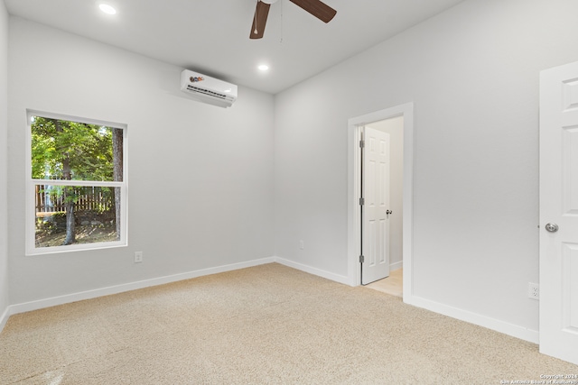 unfurnished room with light colored carpet, an AC wall unit, and ceiling fan