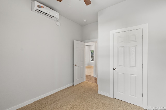 unfurnished bedroom with a closet, ceiling fan, an AC wall unit, and light colored carpet