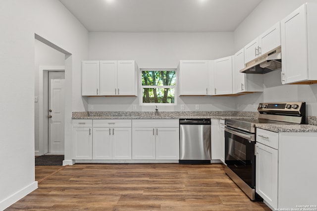 kitchen with white cabinetry, light stone counters, appliances with stainless steel finishes, and dark hardwood / wood-style floors