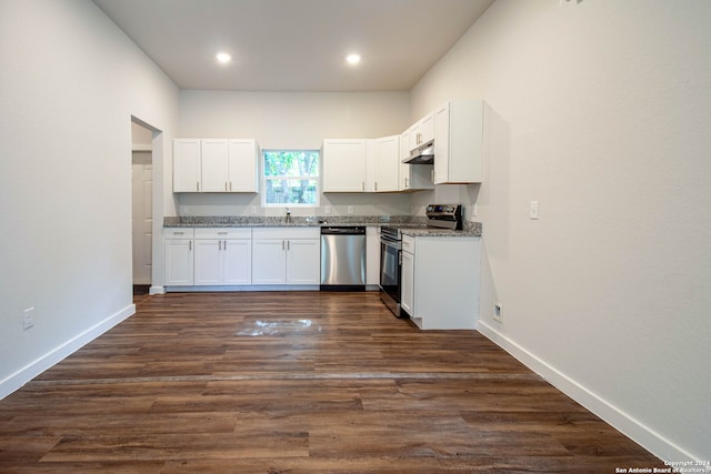 kitchen featuring dark wood-type flooring, dark stone countertops, sink, white cabinetry, and appliances with stainless steel finishes