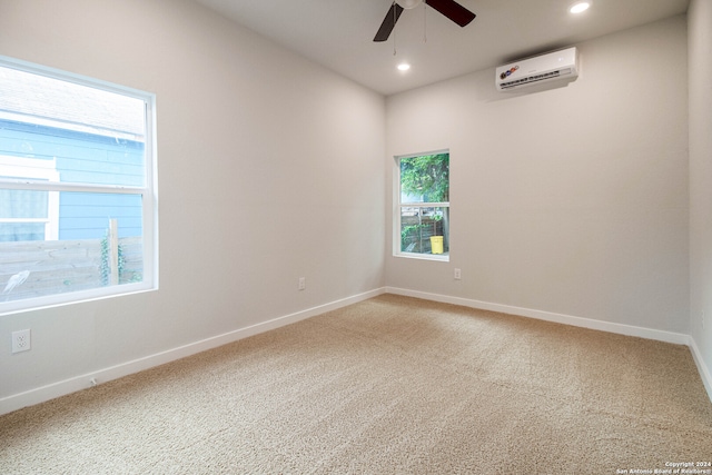 empty room featuring a wall mounted air conditioner, ceiling fan, and a wealth of natural light