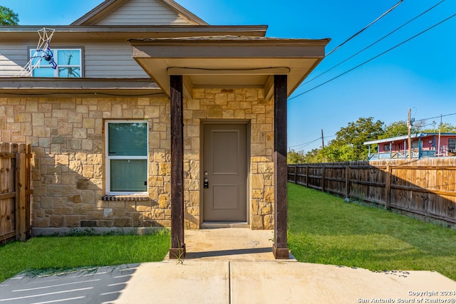 view of exterior entry featuring a yard