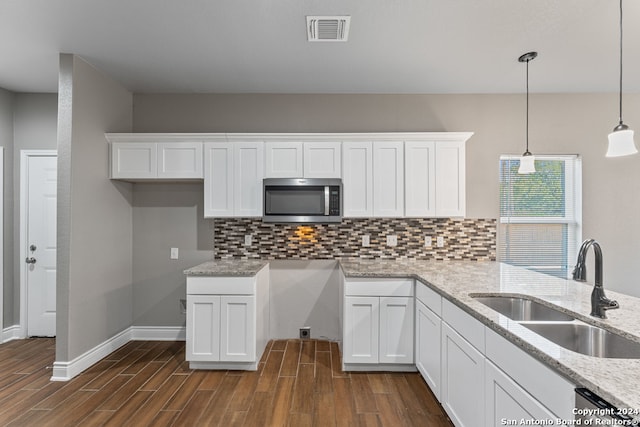 kitchen featuring white cabinetry, hanging light fixtures, stainless steel appliances, and sink