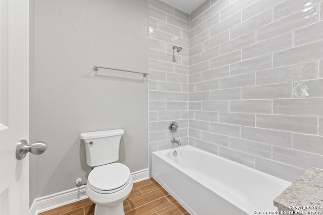 full bathroom with toilet, tiled shower / bath combo, and vanity