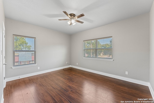 empty room with dark hardwood / wood-style floors and ceiling fan