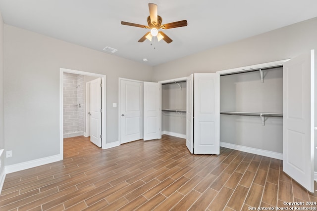 unfurnished bedroom with multiple closets, light wood-type flooring, and ceiling fan