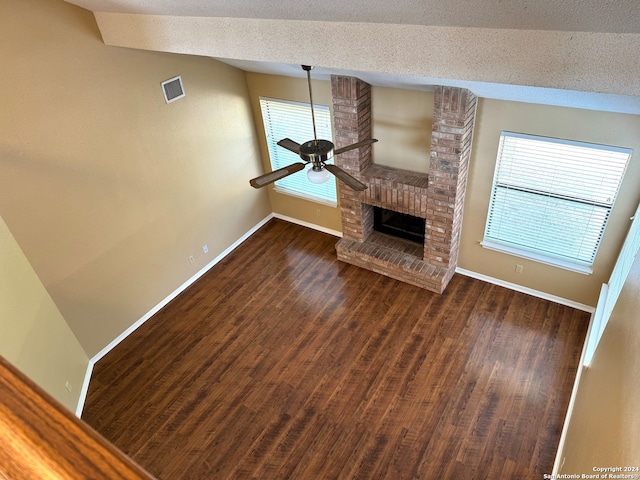 unfurnished living room with ceiling fan, a textured ceiling, vaulted ceiling, and dark hardwood / wood-style flooring