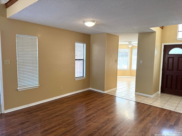 foyer entrance featuring ceiling fan, a textured ceiling, and light wood-type flooring