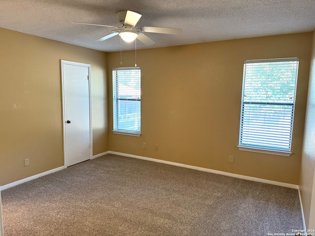 spare room featuring a textured ceiling, carpet, and ceiling fan