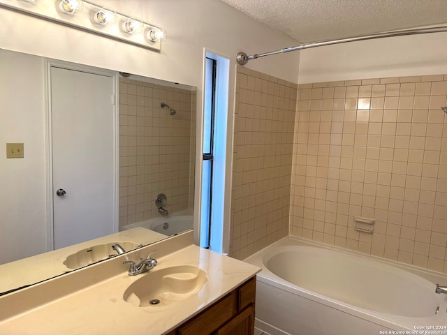 bathroom featuring vanity, tiled shower / bath combo, and a textured ceiling