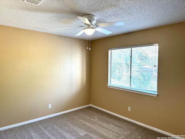 carpeted spare room with ceiling fan and a textured ceiling