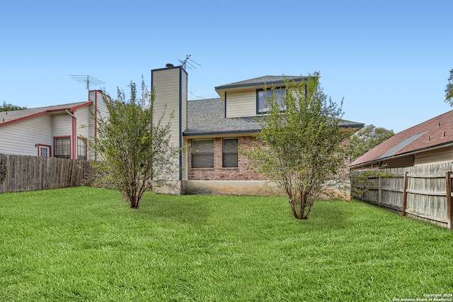 rear view of house featuring a yard