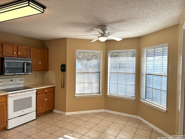 kitchen with electric stove, a textured ceiling, light tile patterned floors, and ceiling fan