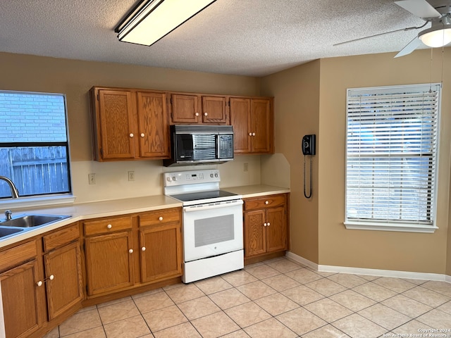 kitchen with a textured ceiling, white electric stove, sink, and light tile patterned floors