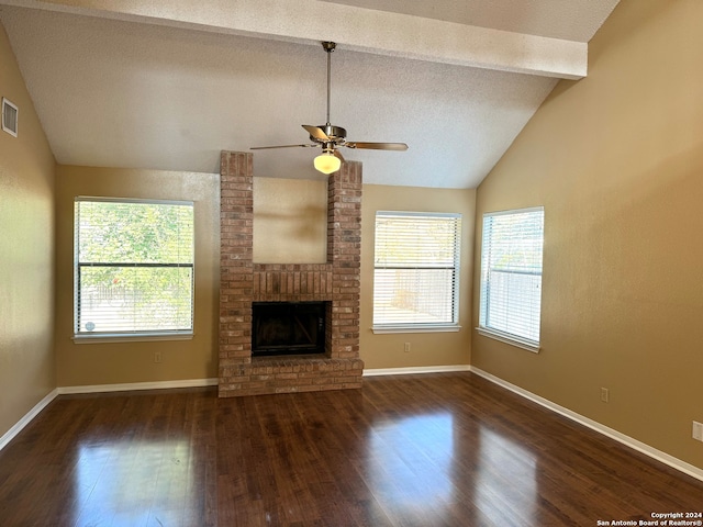 unfurnished living room with dark hardwood / wood-style floors, lofted ceiling with beams, and plenty of natural light