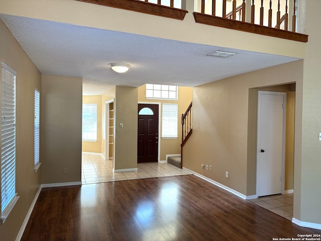 foyer with a textured ceiling and light wood-type flooring