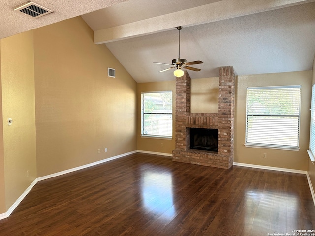 unfurnished living room with ceiling fan, dark hardwood / wood-style flooring, a textured ceiling, a fireplace, and lofted ceiling with beams