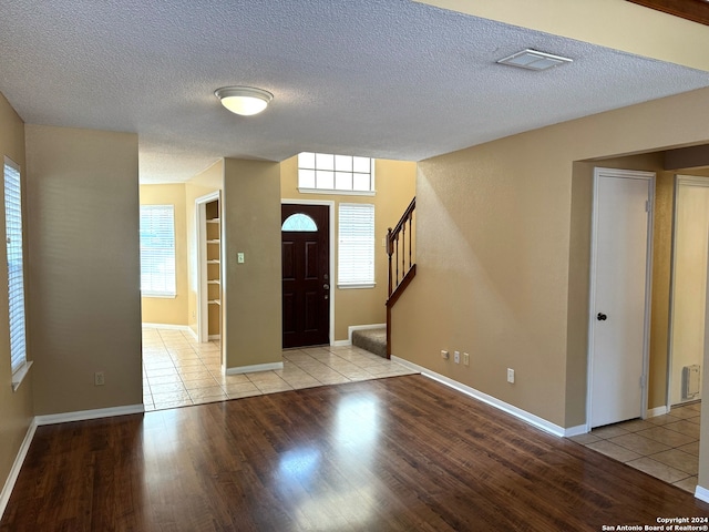 entrance foyer featuring a textured ceiling, light hardwood / wood-style floors, and plenty of natural light