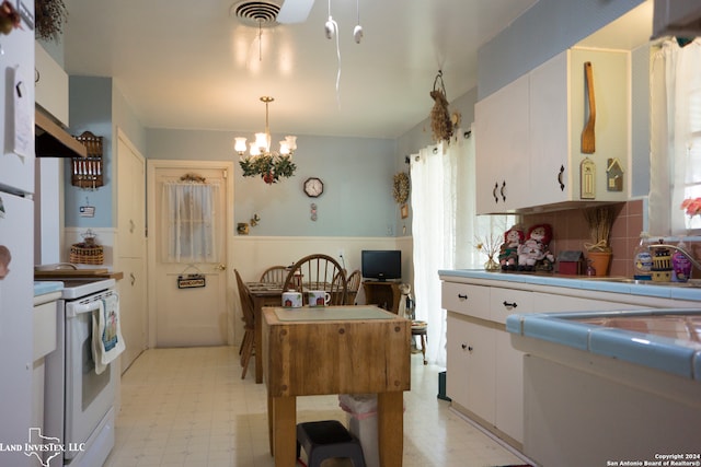 kitchen featuring white cabinetry, white electric range, decorative light fixtures, and tile countertops