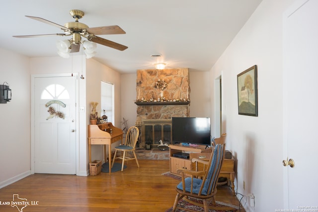 foyer featuring dark hardwood / wood-style floors, a fireplace, and ceiling fan