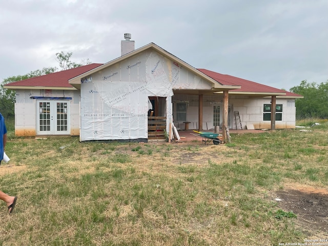 rear view of property featuring a lawn