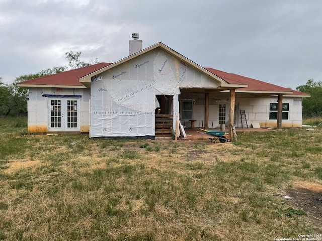 rear view of house featuring a yard