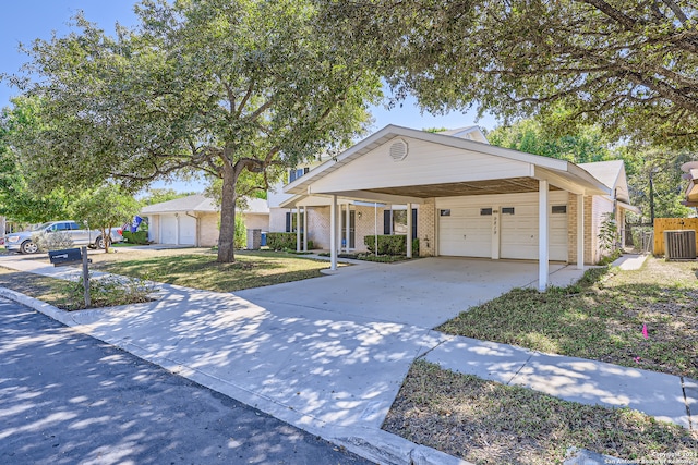 single story home featuring a front lawn, central AC unit, a garage, and a carport