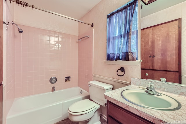 full bathroom featuring tiled shower / bath, vanity, and toilet