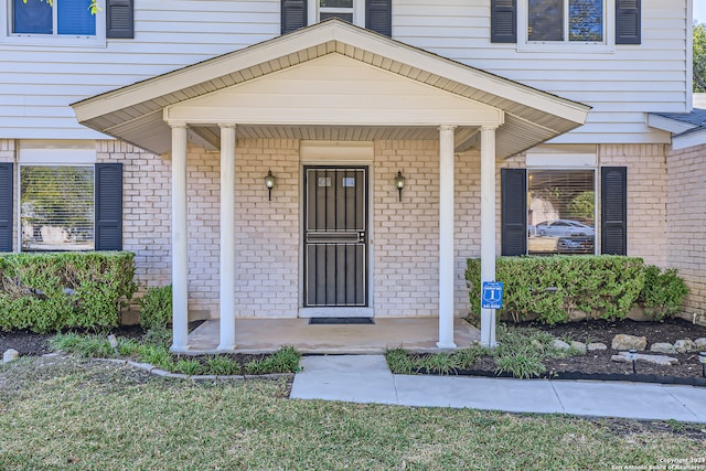 property entrance featuring a yard and a porch