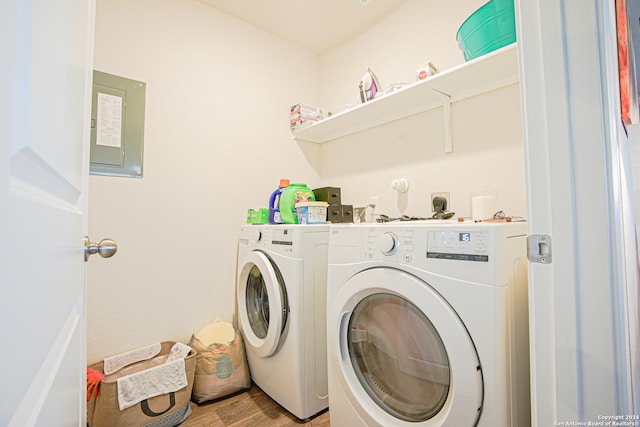 laundry area featuring electric panel, washer and dryer, and light wood-type flooring