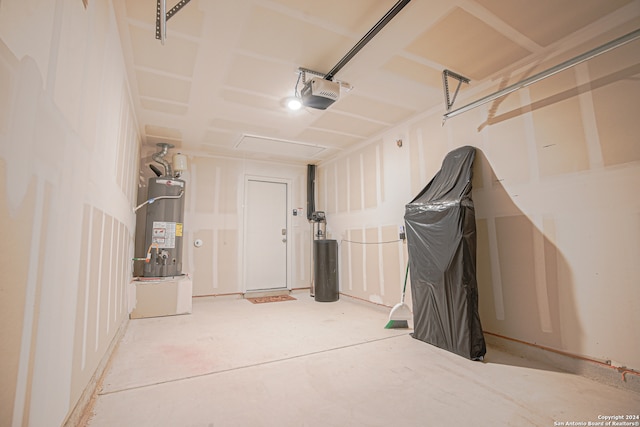 garage featuring strapped water heater and a garage door opener