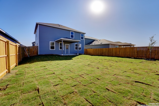 rear view of house featuring a patio area and a yard