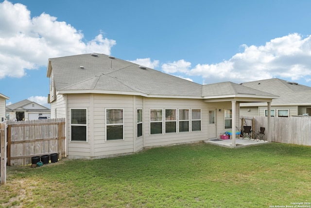 rear view of house with a patio and a lawn