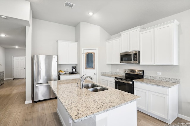 kitchen featuring appliances with stainless steel finishes, white cabinets, sink, and an island with sink