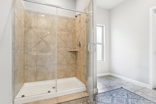 bathroom featuring a shower with door and tile patterned flooring