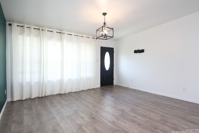 foyer entrance featuring hardwood / wood-style floors and a notable chandelier