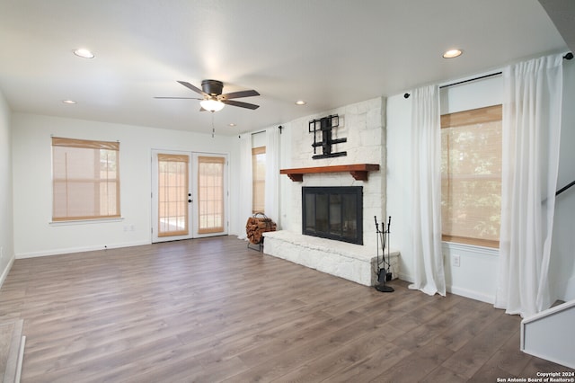 unfurnished living room featuring french doors, ceiling fan, hardwood / wood-style flooring, and a fireplace