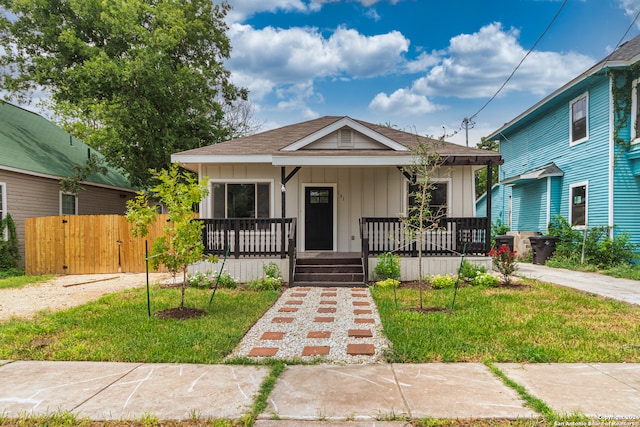 bungalow-style house with a front yard and covered porch