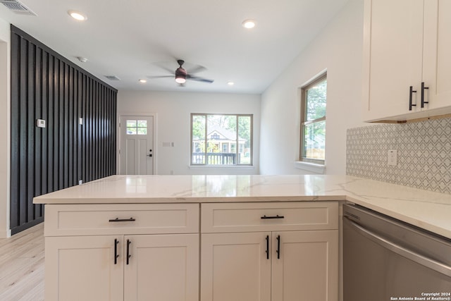 kitchen featuring light hardwood / wood-style flooring, kitchen peninsula, dishwasher, and white cabinets