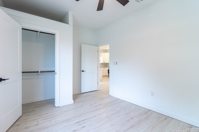 unfurnished bedroom featuring light hardwood / wood-style flooring, a closet, and ceiling fan