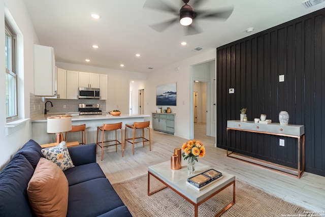 living room featuring light wood-type flooring and ceiling fan