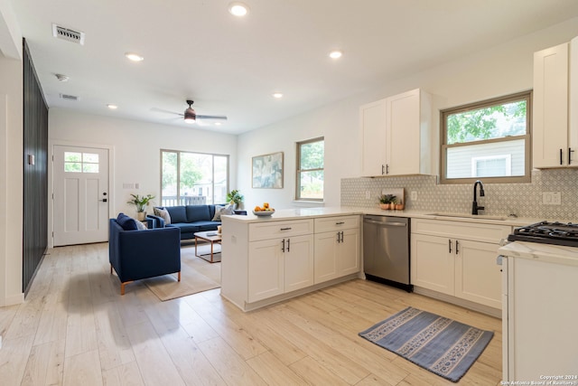 kitchen featuring sink, dishwasher, kitchen peninsula, white cabinetry, and light hardwood / wood-style floors