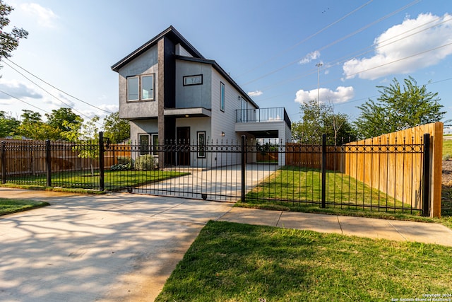 view of front of house with a balcony and a front lawn