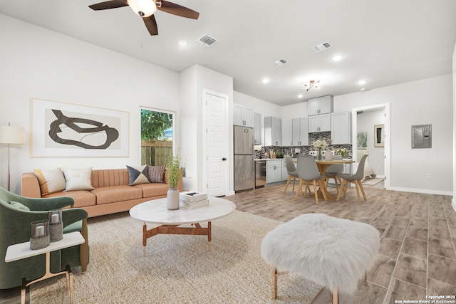 living room with light hardwood / wood-style floors and ceiling fan