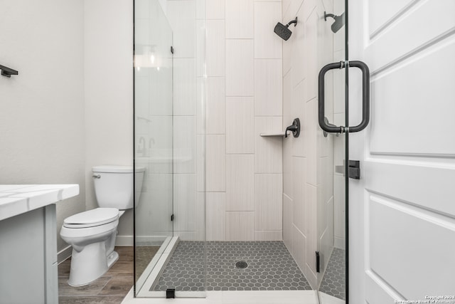 bathroom with vanity, toilet, hardwood / wood-style flooring, and walk in shower