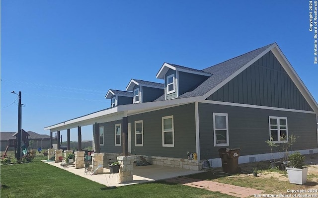 view of property exterior with a patio and a lawn