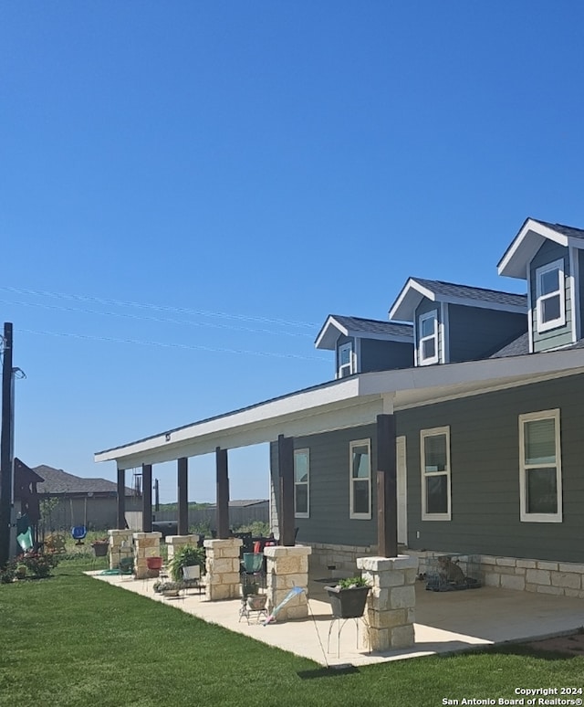 back of property featuring a patio and a yard