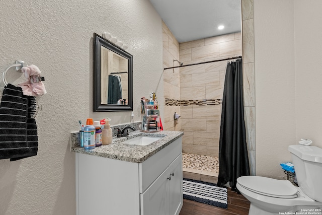 bathroom featuring vanity, a shower with shower curtain, wood-type flooring, and toilet