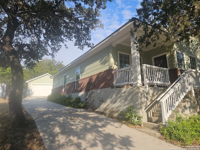 view of front of property featuring a porch, an outbuilding, and a garage